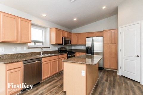 A kitchen with wooden cabinets and a refrigerator.