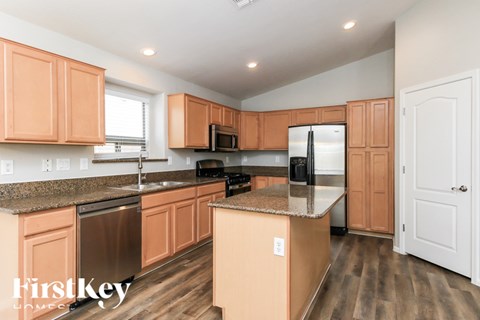 A kitchen with wooden cabinets and a refrigerator.