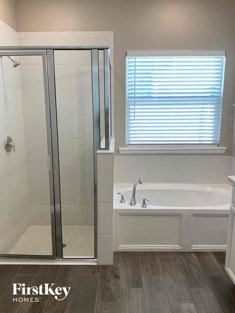 a bathroom with a tub and a shower and a window