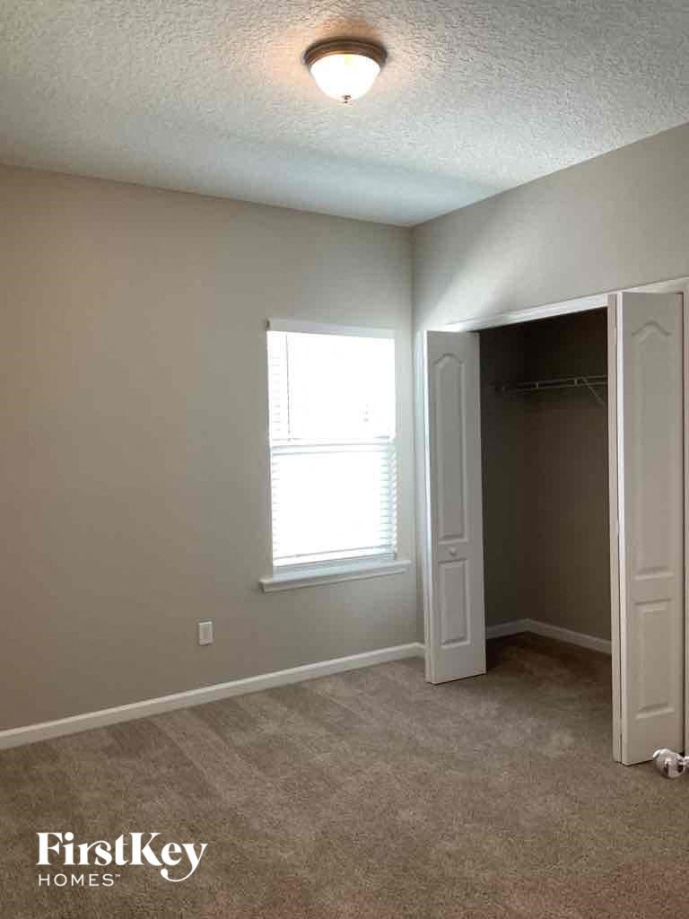 a bedroom with a closet and a window and a door to a closet