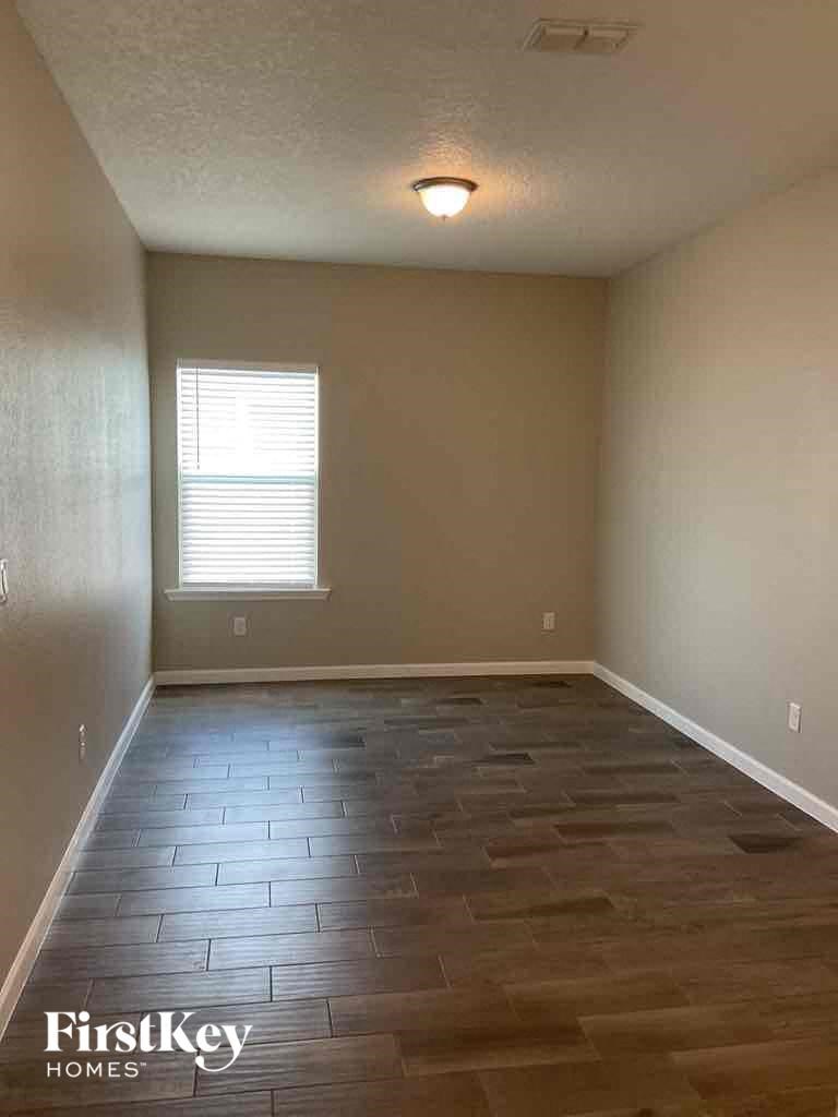 a empty living room with wood floors and a window