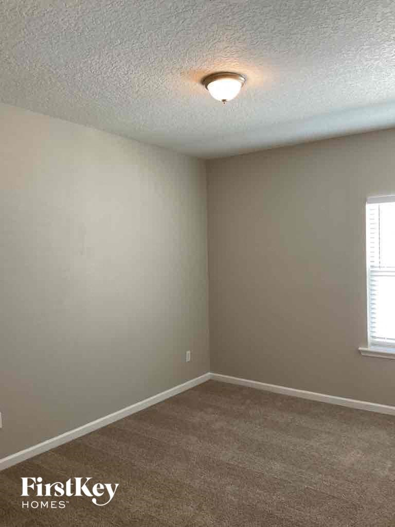 an empty living room with a light on the ceiling