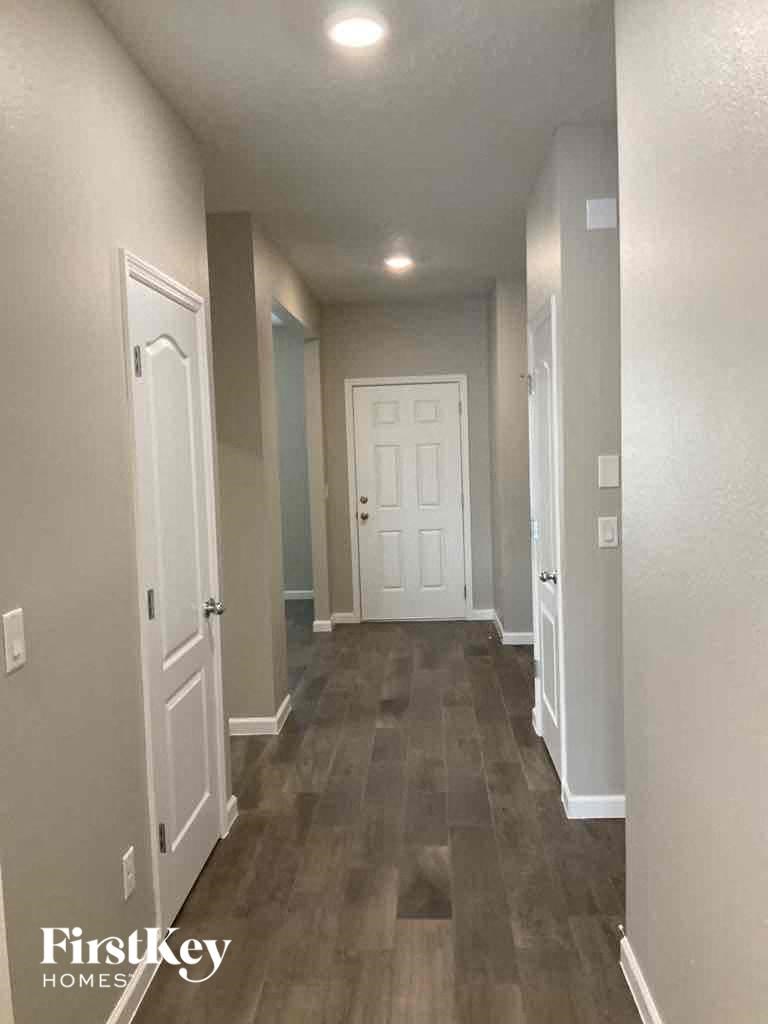 a hallway with a white door and wood flooring