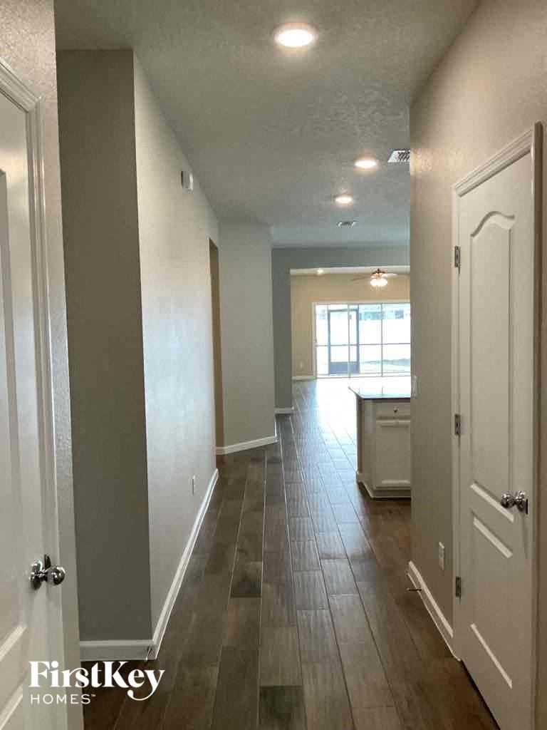a long hallway with a hard wood floor and white walls