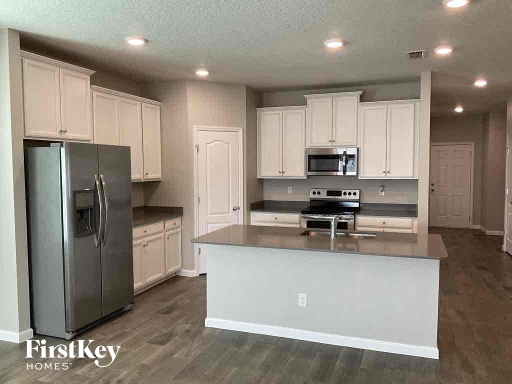 an updated kitchen with white cabinets and stainless steel appliances