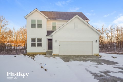 a white house with a garage in the snow