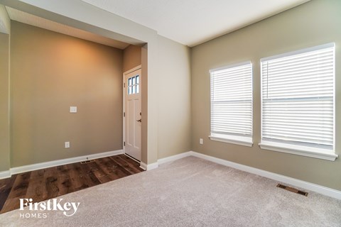 an empty room with a door and three windows