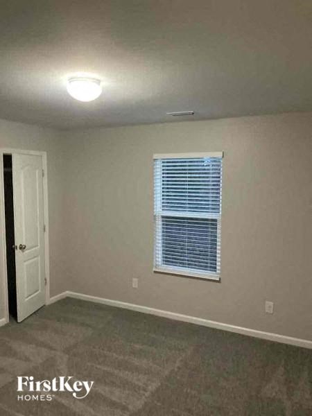 an empty room with a window and a white door