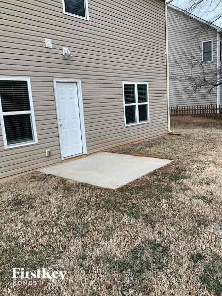 a yard with a patio in front of a house