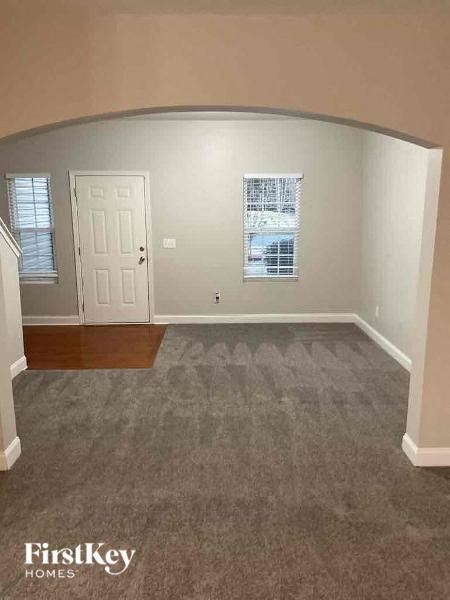 an empty living room with a door and a carpet