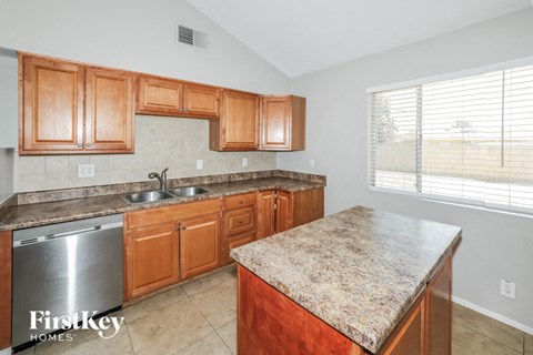 a kitchen with wooden cabinets and granite counter tops and a sink