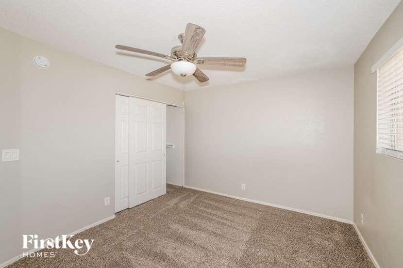 a living room with a ceiling fan and a closet