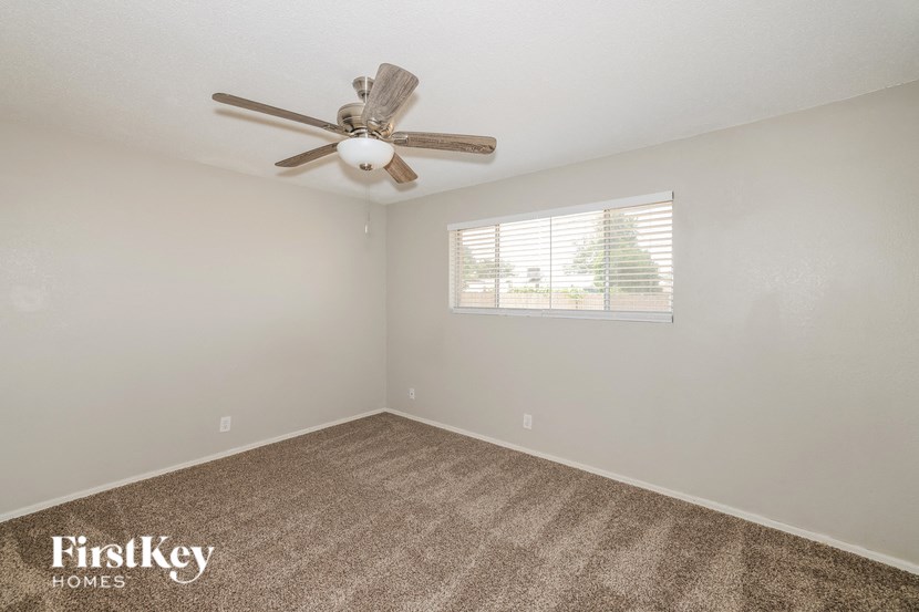 a bedroom with a ceiling fan and a window