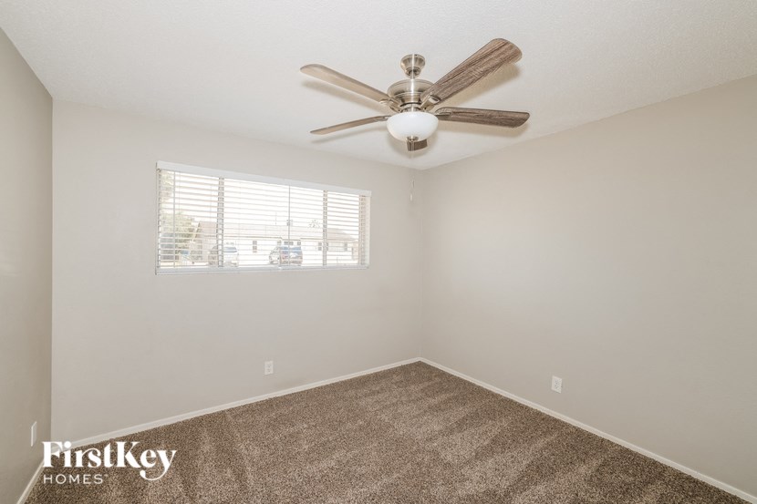 a bedroom with a ceiling fan and a window