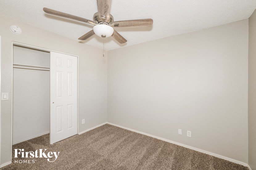 a bedroom with a ceiling fan and a closet