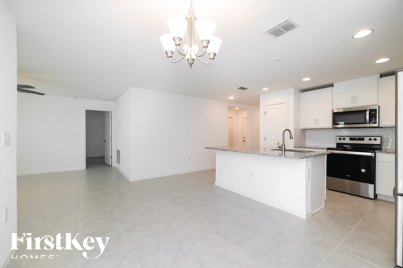 A spacious kitchen with white cabinets and a central island.