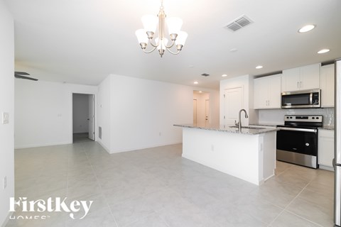 A spacious kitchen with white cabinets and a central island.