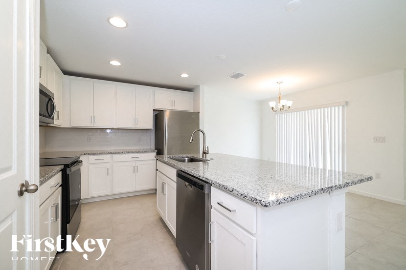 A kitchen with granite countertops and stainless steel appliances.