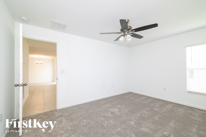 A spacious room with a ceiling fan and a carpeted floor.