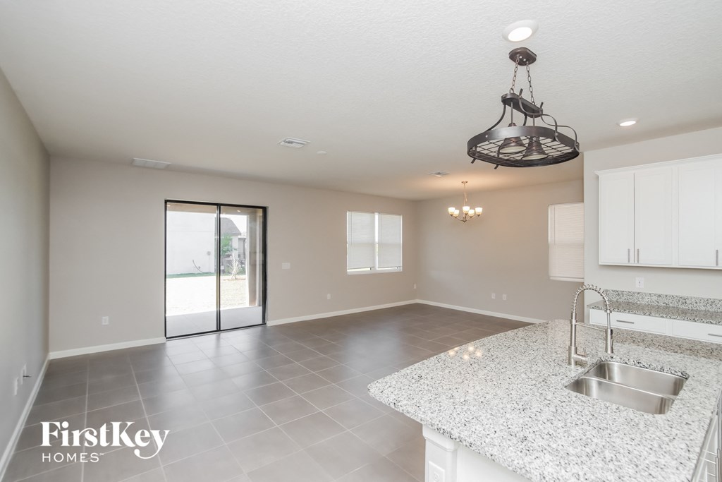 an open kitchen and living room with a stainless steel sink and counter top