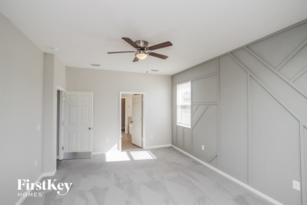 a master bedroom with a ceiling fan and a large closet