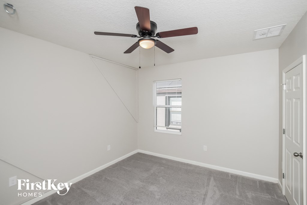 a living room with a ceiling fan and a window