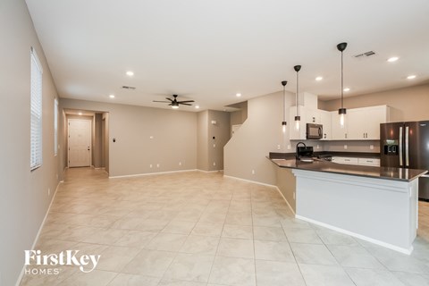 A spacious kitchen and living room with a staircase leading to the upper level.