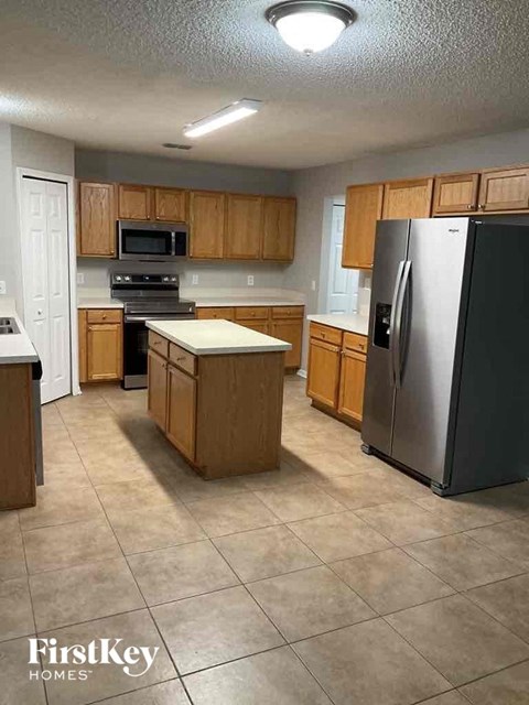 A kitchen with wooden cabinets and a refrigerator.