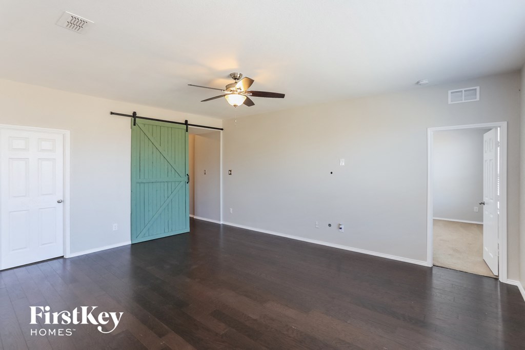 a living room with a ceiling fan and a door to a closet