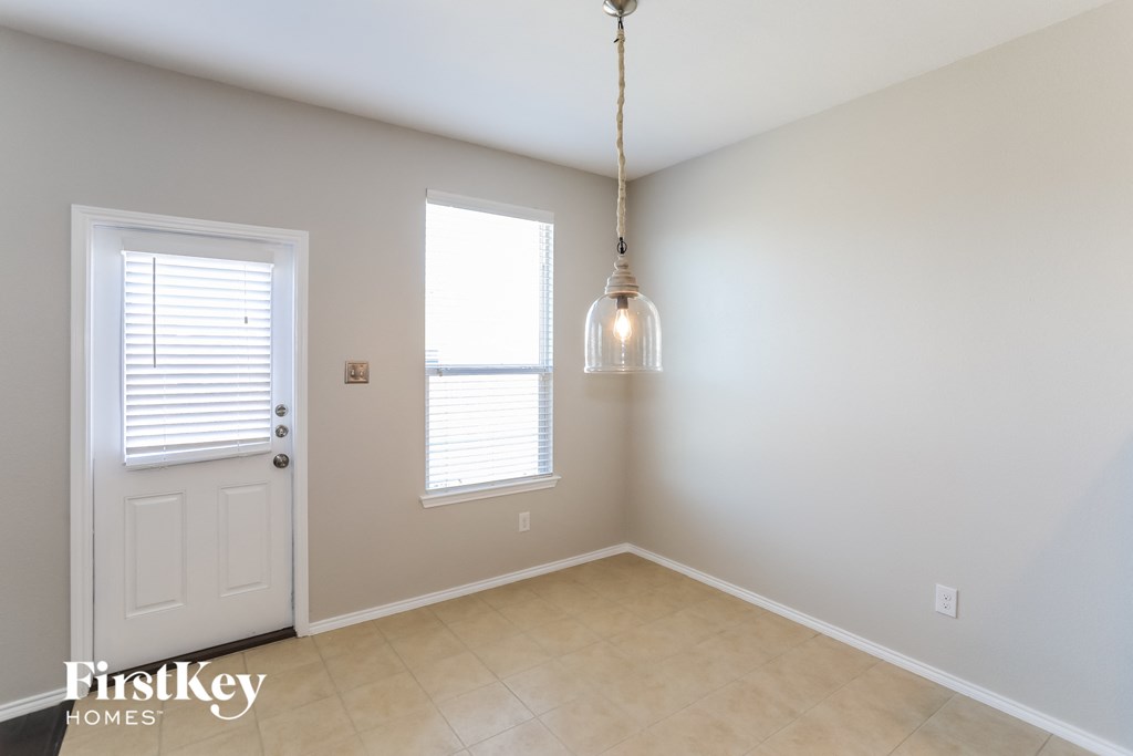 an empty dining room with a light fixture and a door