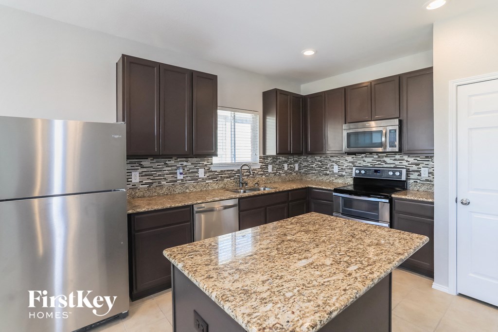 an updated kitchen with granite counter tops and stainless steel appliances