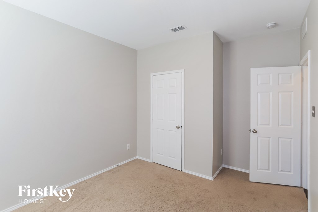a bedroom with two white doors and a carpeted floor