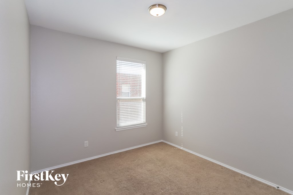 a bedroom with a carpeted floor and a window