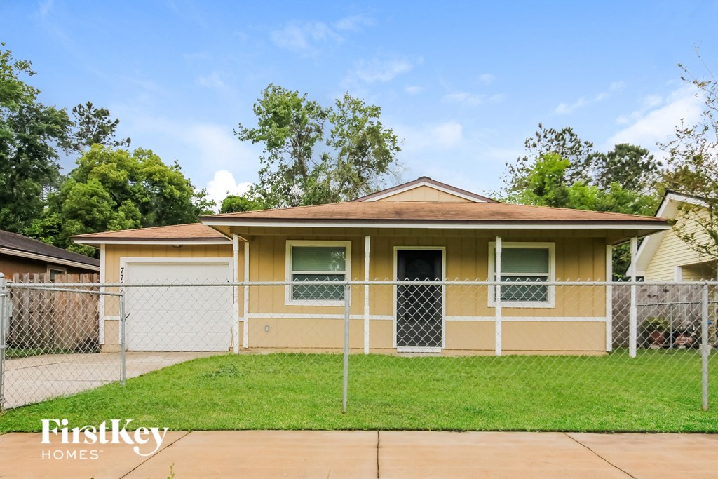 a house with a fenced in yard and a chain link fence