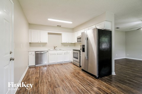 a kitchen with white cabinets and a stainless steel refrigerator