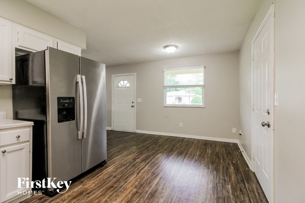 an empty kitchen with a refrigerator and a window