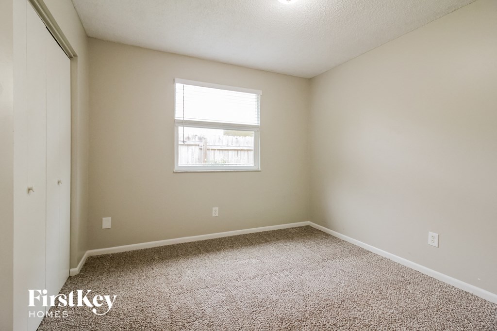 an empty room with carpet and a window