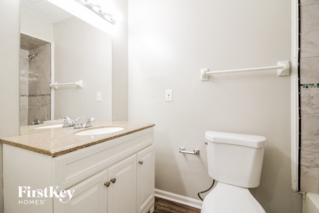 a white bathroom with a white toilet and a sink