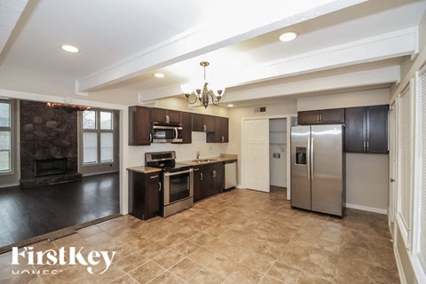 A kitchen with a refrigerator, oven, and microwave.