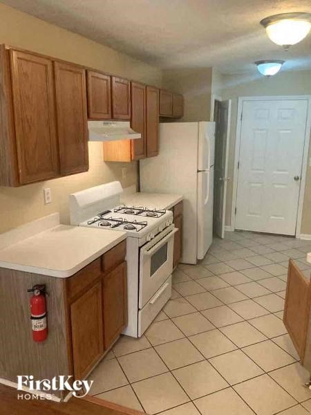A kitchen with a stove top oven and a refrigerator.