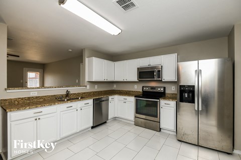a kitchen with white cabinets and stainless steel appliances