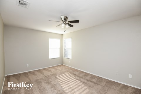 a living room with carpet and a ceiling fan