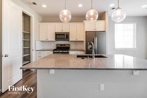 a kitchen with white cabinets and a granite counter top