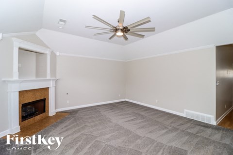A room with a fireplace and a ceiling fan.