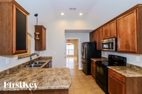 A kitchen with wooden cabinets and black appliances.