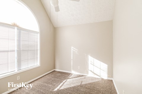 a living room with a large window and a carpet