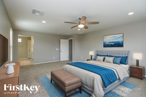 A bedroom with a large bed and a ceiling fan.
