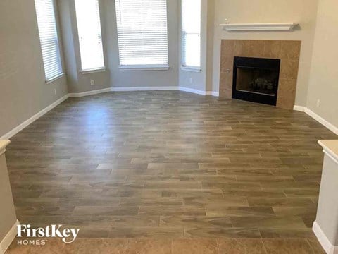 a living room with a wood floor and a fireplace