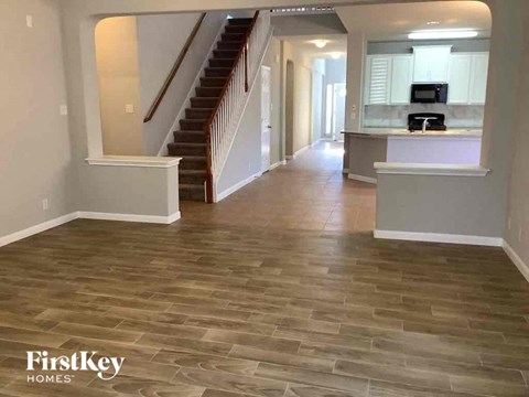 a living room with a hard wood floor and a staircase