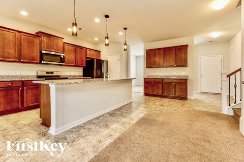 A kitchen with wooden cabinets and a white island.